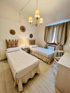 una camera con due letti e un lampadario a braccio di Villino in Campagna con Piscina Relax - La Casa di Teresa a Campomarino