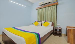 a bedroom with a bed and a tv on the wall at Itsy Hotels Sidhartha Residency in Bhubaneshwar