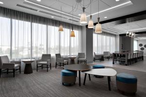 a waiting room with tables and chairs and a piano at Residence Inn by Marriott Knoxville Downtown in Knoxville