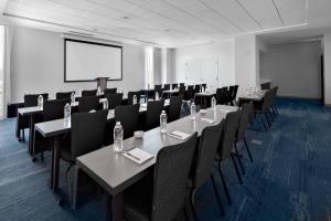 a conference room with tables and chairs and a screen at Residence Inn by Marriott Knoxville Downtown in Knoxville