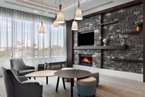 a living room with a fireplace and a tv at Residence Inn by Marriott Knoxville Downtown in Knoxville