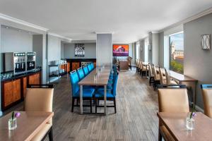 un restaurante con mesas de madera y sillas azules en JW Marriott Washington, DC, en Washington
