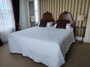 a bedroom with a large white bed with two pillows at Dalkeith Boutique Bed & Breakfast in Kaiapoi