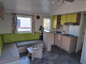 a small kitchen with a couch and a table at Mobil home confort 6 personnes in Saint-Chéron