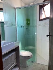 uma casa de banho com um WC e uma cabina de duche em vidro. em Rio Grande Beach House em Rio Grande