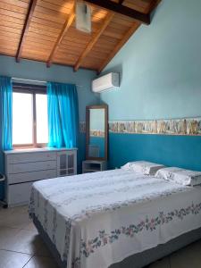 um quarto com uma cama e uma parede azul em Rio Grande Beach House em Rio Grande