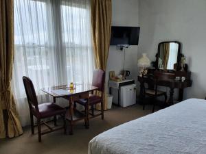 um quarto de hotel com uma mesa, uma secretária e uma cama em Dalkeith Boutique Bed & Breakfast em Kaiapoi