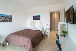 a bedroom with a large bed and a television at Nni Mia in Modica