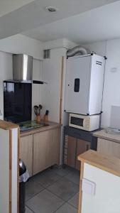 a kitchen with a white refrigerator and a microwave at Appartement entier Bourges Avaricum centre ville in Bourges