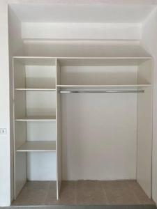 um armário vazio com prateleiras brancas num quarto em Hermosa Casa en Chacras de Coria em Chacras de Coria