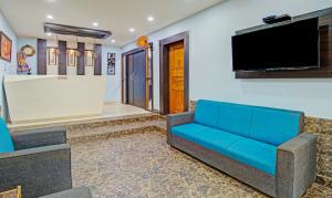 a living room with a blue couch and a flat screen tv at Itsy By Treebo - Sidhartha Residency in Bhubaneshwar