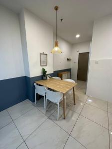 a dining room with a wooden table and white chairs at Blest Loft 7 Manhattan Suites ITCC in Penampang