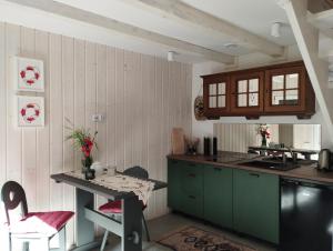 a kitchen with green cabinets and a table at Wilkovo Roztocze in Hutków