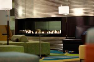 a living room with a fireplace and a couch at Marriott Montreal Airport In-Terminal Hotel in Dorval