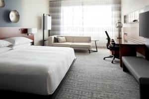 a hotel room with a large bed and a desk at Marriott Montreal Airport In-Terminal Hotel in Dorval