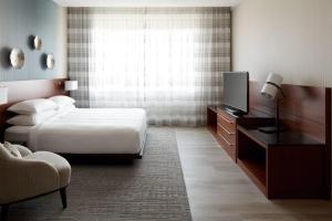 a hotel room with a bed and a television at Marriott Montreal Airport In-Terminal Hotel in Dorval