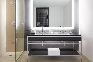 a bathroom with a sink and a mirror at Marriott Montreal Airport In-Terminal Hotel in Dorval