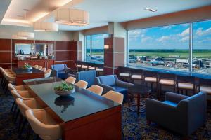a waiting room at an airport with chairs and tables at Marriott Montreal Airport In-Terminal Hotel in Dorval