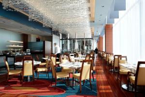 a dining room with tables and chairs in a restaurant at Marriott Montreal Airport In-Terminal Hotel in Dorval