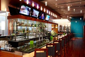 a bar with a person standing behind the bar at Marriott Montreal Airport In-Terminal Hotel in Dorval