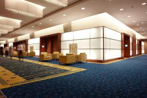 a lobby of a hotel with chairs and tables at Marriott Montreal Airport In-Terminal Hotel in Dorval