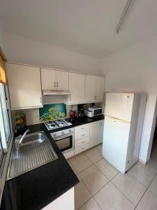 a kitchen with white cabinets and a white refrigerator at Three Bedroom Casa de Paphos in Paphos City