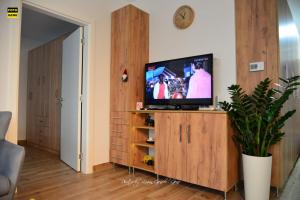 a living room with a television on a wooden cabinet at Apartment No 11 in Subotica