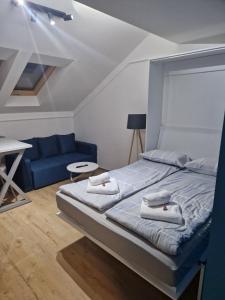 een slaapkamer met een bed en een blauwe bank bij Ancora apartment 5 in Novi Sad