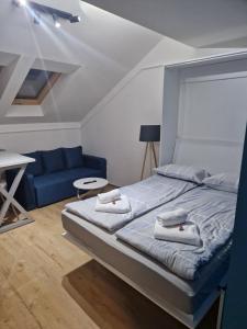 a bedroom with a bed and a blue couch at Ancora apartment 5 in Novi Sad