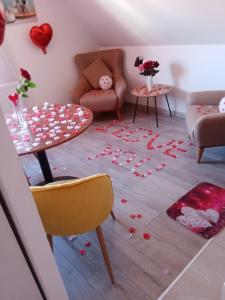 ein Wohnzimmer mit einem Tisch und Rosen auf dem Boden in der Unterkunft Studio Jacuzzi au centre Colmar in Colmar