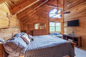um quarto com uma cama num chalé de madeira em Knotty By Nature em Sevierville