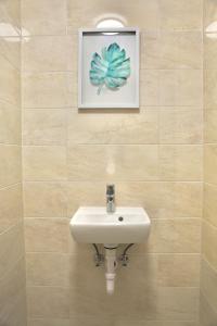 łazienka z umywalką i zdjęciem na ścianie w obiekcie L&L HOME w Budapeszcie