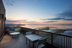 桑德貝的住宿－Delta Hotels by Marriott Thunder Bay，阳台配有桌椅,享有水景。
