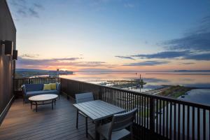 uma varanda com mesa e cadeiras e vista para a água em Delta Hotels by Marriott Thunder Bay em Thunder Bay