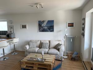 ein Wohnzimmer mit einem Sofa und einem Couchtisch in der Unterkunft Apartment am See in Scharbeutz
