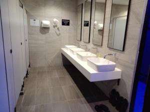 a bathroom with two sinks and two mirrors at Sovotel @ Napzone KKIA in Kota Kinabalu