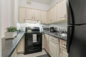 uma cozinha com armários de madeira e um frigorífico preto em 1BR Apartment with Spacious Living Area - Chestnut 07B em Chicago