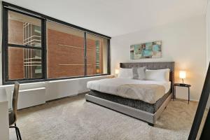 um quarto com uma cama e uma grande janela em 1BR Apartment with Spacious Living Area - Chestnut 07B em Chicago