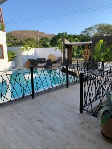 un patio con una mesa de cristal y una piscina en Luana Suites- Suite Maya en Zihuatanejo