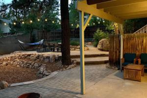 a patio with a tree and a hammock in a yard at Elden House - Perfect Mountain Escape for Groups & Families! in Flagstaff