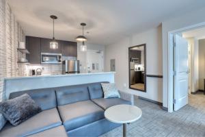 a living room with a blue couch and a kitchen at Residence Inn by Marriott Providence Lincoln in Lincoln