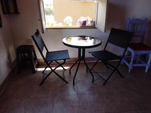a table and chairs in a room with a window at El Cardón,habitación privada en el campo in Humahuaca +20 photos