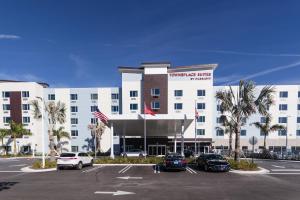 un gran edificio blanco con coches aparcados en un aparcamiento en TownePlace Suites Port St. Lucie I-95 en Port Saint Lucie