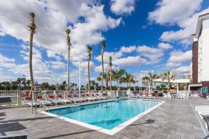 a swimming pool with chaise lounge chairs and palm trees at TownePlace Suites Port St. Lucie I-95 in Port Saint Lucie