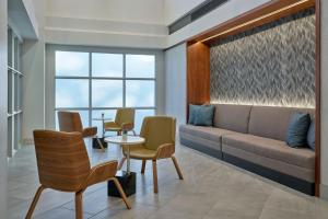 a waiting room with a couch and chairs and a table at Delta Hotels by Marriott Little Rock West in Little Rock