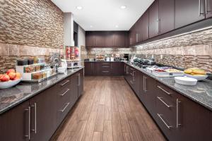 a large kitchen with brown cabinets and wooden floors at Residence Inn Phoenix NW/Surprise in Surprise