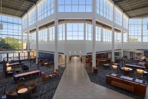 a rendering of the lobby of a building with tables and chairs at Delta Hotels by Marriott Little Rock West in Little Rock