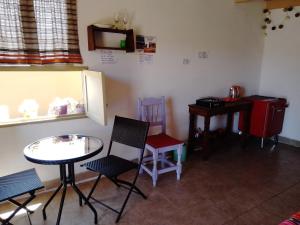 um quarto com uma mesa e cadeiras, uma mesa e uma secretária em El Cardón,habitación privada en el campo em Humahuaca
