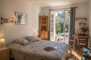 een slaapkamer met een bed en een tafel met een boek erop bij Le Mas des Gardettes in Saint-Paul-de-Vence