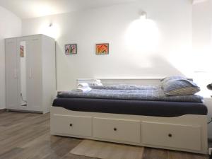een bed in een kamer met een witte muur bij Good Vibrations Apartments in Zagreb